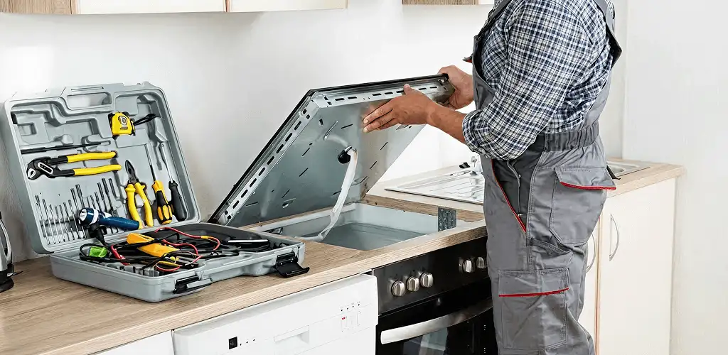 Handyman repairing a cooktop and checking wiring connections in Boca Raton, FL
