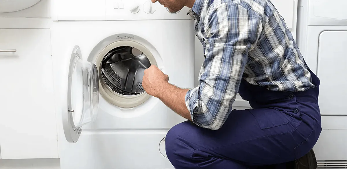 Handyman inspecting a dryer drum and internal parts for repair in Boca Raton, FL