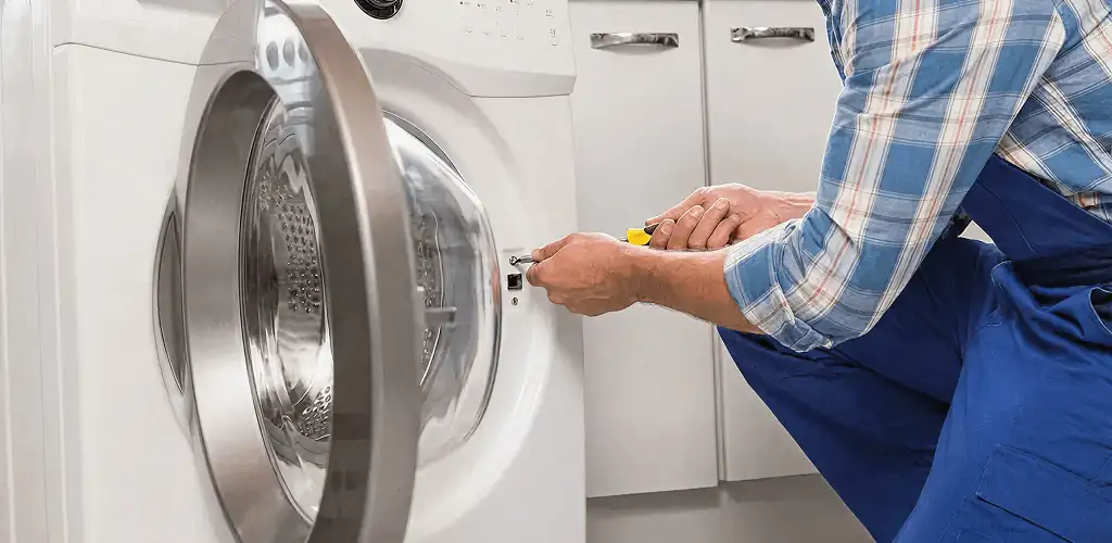 Handyman repairing a clothes dryer and checking electrical connections in Boca Raton, FL