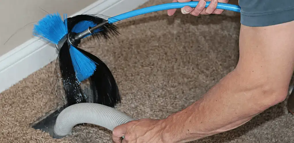 Dryer vent cleaning technician brushing lint from a vent line in Boca Raton, FL