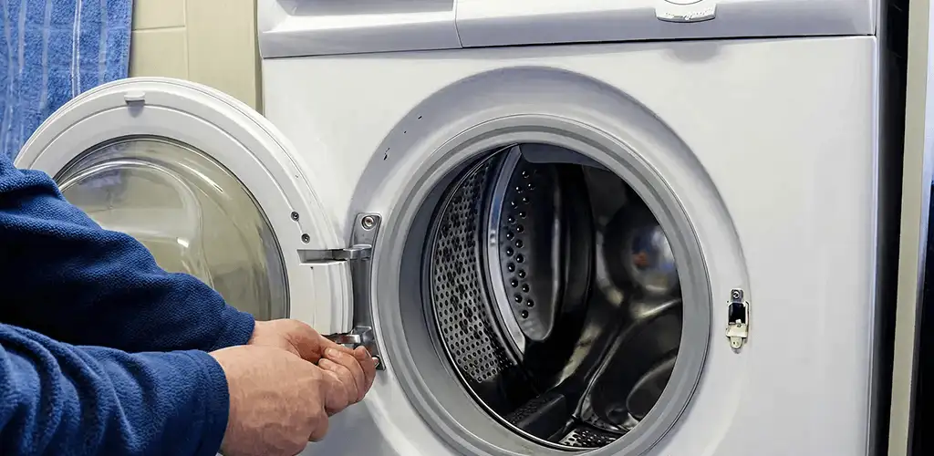 Washing machine repair handyman checking a front-load washer door and latch in Boca Raton, FL