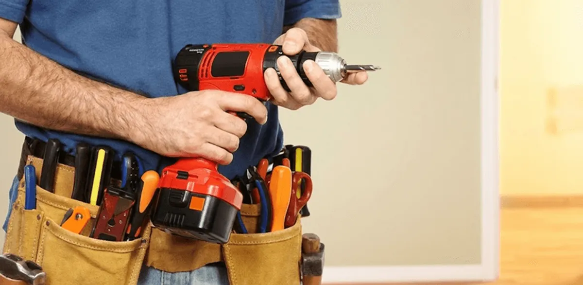 Handyman holding a power drill for home repairs and installations in Boca Raton, FL