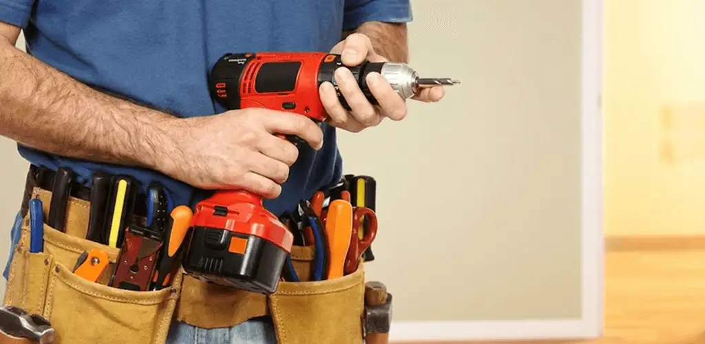 Handyman holding a power drill for home repairs and installations in Boca Raton, FL