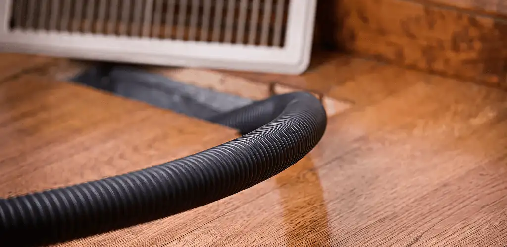 Air duct cleaning hose inserted into a floor vent for ductwork cleaning in Boca Raton, FL