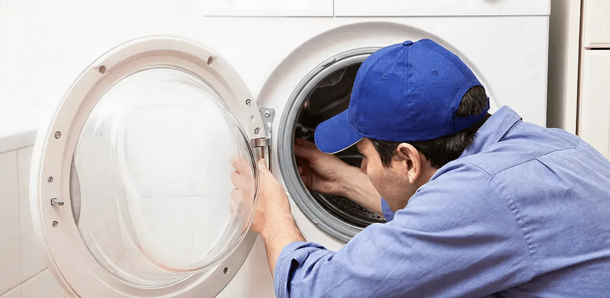 Washing machine repair handyman inspecting a front-load washer drum in Boca Raton, FL