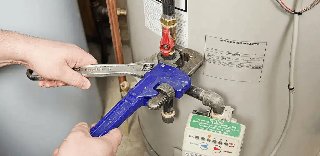 Water heater repair technician tightening the shutoff valve and supply line in Boca Raton, FL